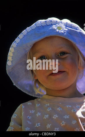 Reino Unido, Inglaterra, retrato de una niña de 3 años de edad con fondo oscuro y retroiluminación.