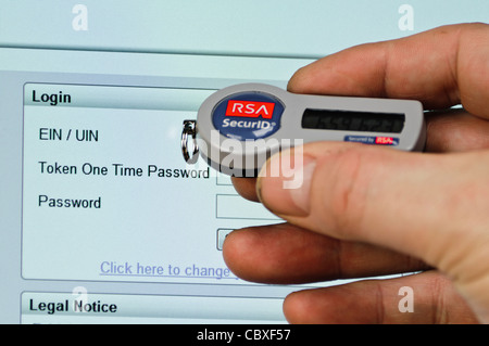 El hombre usa token SecurID para iniciar sesión en un sitio web que necesitan un nombre de usuario, contraseña y contraseña Foto de stock