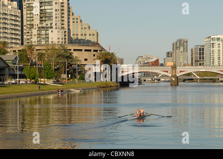 Temprano en la mañana de remo en el río Yarra, en el centro de Melbourne, con el Southbank (izq.) y el CDB (r.) en Melbourne, Victoria, Australia