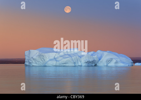 Iceberg a la puesta del sol y luna en el Hall Bredning, Scoresby sund, Groenlandia Foto de stock