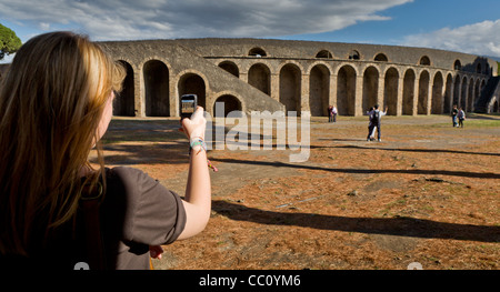 Las paredes exteriores del antiguo anfiteatro romano, Pompeya, Italia Teen tomando fotos con un teléfono celular