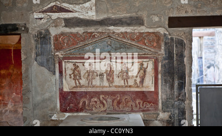 Lararium (Santuario) fresco en el atrio de la antigua taberna Pompeya Italia