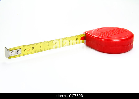 Medidor para medir en rojo sobre un fondo blanco. Foto de stock
