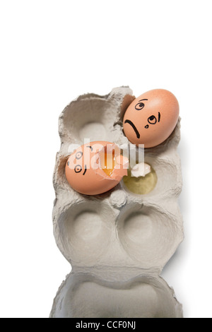 Los huevos en una caja de cartón con un huevo roto Foto de stock