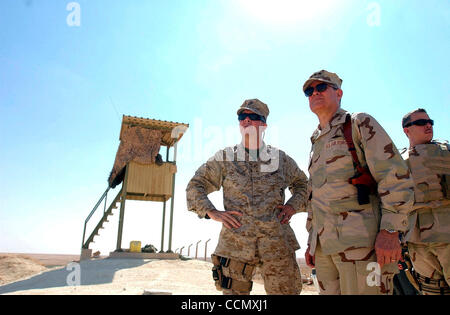 Jul 06, 2004; Bagdad, Irak; El Teniente Coronel de la Fuerza Aérea de los EE.UU. Lance Smith (C) habla con el Cuerpo de Marines de EE.UU Gral. Gen. KEITH STADLER (L) como se ven a través de una sección de la base aérea de Al Asad Martes 6 de julio de 2004 como miembro de Smith's detalle de seguridad mantiene vigilancia en el Iraq.