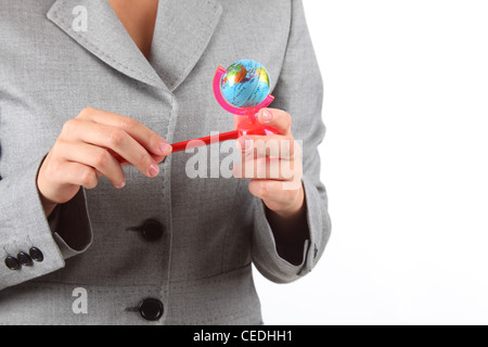 Manos de mujer con un pequeño globo terráqueo sacapuntas Foto de stock