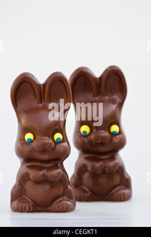 Conejitos de chocolate de Pascua desenvolvían dos dulces aislados recorte recortado en fondo blanco vista frontal de primer plano vertical de alta resolución Foto de stock