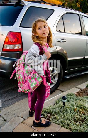 Llevando su mochila y box lunch, una niña de 6 años de espera por el coche  para ir a la escuela en San Juan Capistrano CA. Modelo de liberación  Fotografía de stock - Alamy