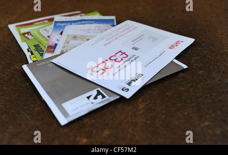 El correo basura en una casa privada en la alfombrilla de la puerta después de ser entregado por el cartero UK Foto de stock