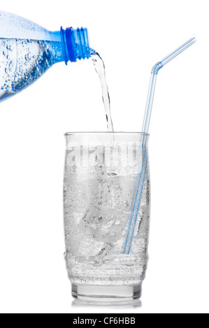 Iced vertiendo agua mineral de botella de plástico en un vaso con cubitos de hielo y paja sobre fondo blanco.