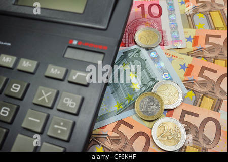 Imagen conceptual con los billetes y monedas en euro y calculadora para ilustrar la crisis bancaria en los países de la Unión Europea Foto de stock
