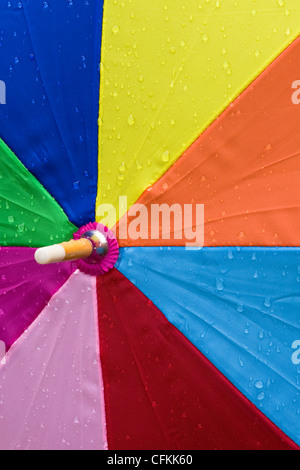 Cierre de un paraguas multicolor en la lluvia.