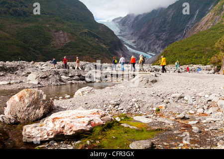 Los turistas que cruzan un puente cerca del glaciar Franz Josef, Costa oeste, Nueva Zelanda.