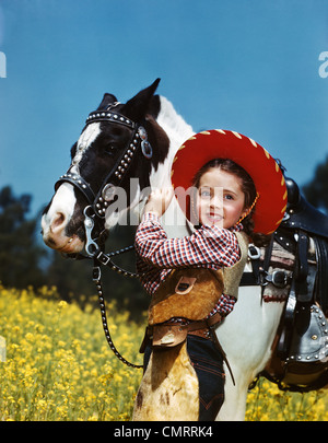 1940 1950 chica sonriente vistiendo ropa vaquera cowboy hat ACARICIÁNDOLE PONY BLANCO Y NEGRO
