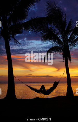 Mujer en hamaca y palmeras al atardecer, Coral Coast, Viti Levu, Fiji, Pacífico Sur