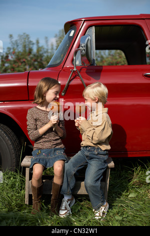 Muchacho y Muchacha comiendo manzanas de toffee por camión Foto de stock