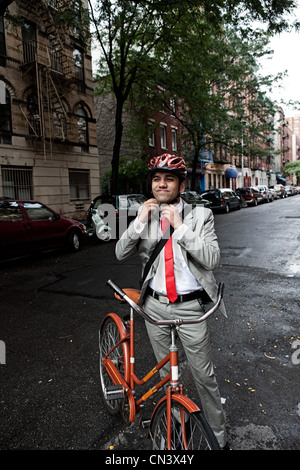 Joven Empresario de ciclo de ajuste de casco en la calle