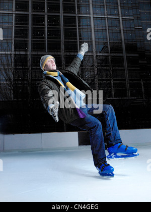 El hombre puede caerse en una pista de patinaje sobre hielo Foto de stock
