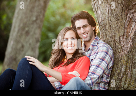 Retrato de la joven pareja sentada en el parque Foto de stock