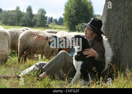 Pastor con el rebaño de ovejas y ovejero apuntando, Alemania, Sajonia
