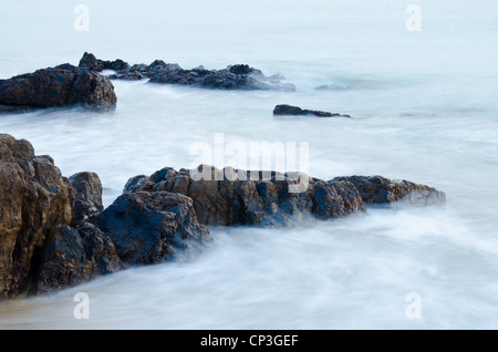 Las olas del mar línea de pestañas de impacto en la playa de roca Foto de stock
