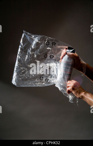 Una bolsa de plástico llena de un aerosol de inhalación de gas para uso ilegal como una droga. Foto de stock