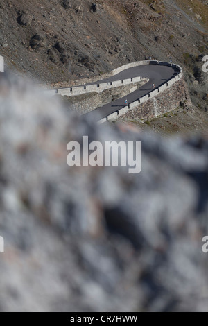 Los ciclistas acercando a una curva cerrada, en zigzag el Stelvio pass road en el Alto Adige, Italia Foto de stock