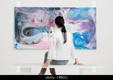 Mujer joven mirando el óleo en la galería