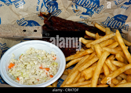 Costillas de cerdo asadas patatas fritas coleslaw almuerzo cuchillo frecuentado restaurante Foto de stock