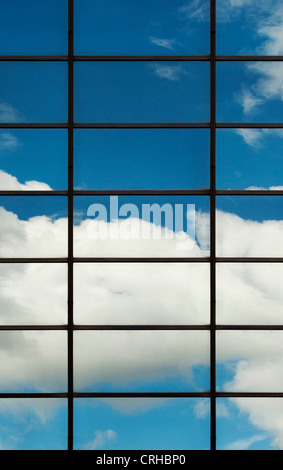 Cielo azul y las nubes reflejan en bloque de oficinas de vidrio. Londres