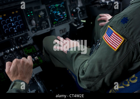 Un piloto de la Fuerza Aérea de EE.UU. mantiene el acelerador las palancas en la cabina de un jet de transporte C-17 en el Salón Aeronáutico de Farnborough, Reino Unido. Foto de stock