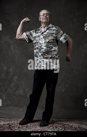 Retrato de un hombre senior flexionando los músculos