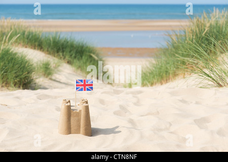 Bandera Union Jack en un castillo de arena en las dunas de arena. Wells junto al mar. Norfolk, Inglaterra Foto de stock