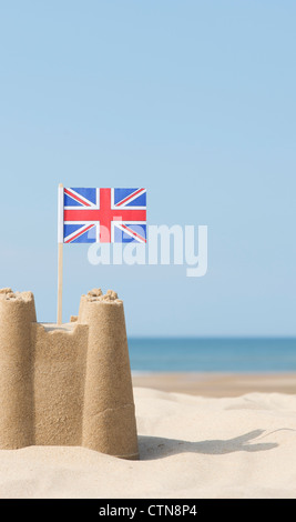 Bandera Union Jack en un castillo de arena en la playa. Wells junto al mar. Norfolk, Inglaterra Foto de stock