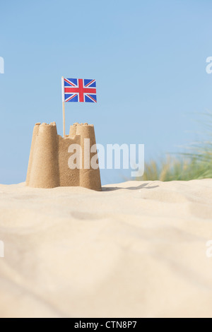 Bandera Union Jack en un castillo de arena en las dunas de arena. Wells junto al mar. Norfolk, Inglaterra Foto de stock
