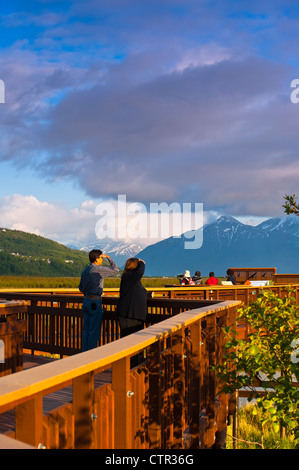 Los visitantes disfrutan de ver boardwalk en Potter Marsh montañas Chugach en segundo plano Southcentral Alaska Primavera Foto de stock