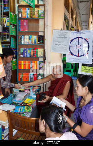 Monje en la librería, Yangon, Myanmar Foto de stock
