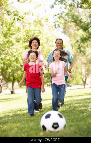 Jugando al fútbol en el parque de la familia
