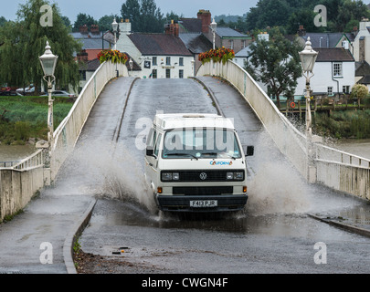 CAMPER VAN conduciendo a través de las inundaciones de verano EN OLD WYE CHEPSTOW Puente El puente es la frontera entre Inglaterra y Gales. Foto de stock