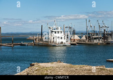 Barcos amarrados en Nahcotta ostras, uno apiladas con conchas reciclados para resiembra camas Willipa Oyster Bay Ocean County Washington. Foto de stock