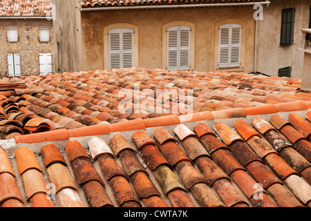 Una vista sobre un techo de tejas terracota hacia las ventanas con persianas en Callas, Provenza, Francia, Europa