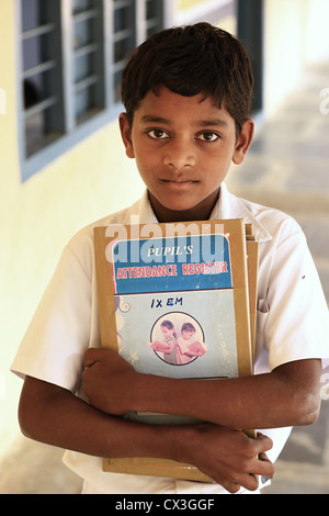 Los jóvenes de la India niño sosteniendo en el registro de asistencia de Andhra Pradesh en el sur de la India Foto de stock