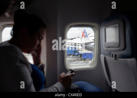 Un pasajero lee un mensaje de teléfono a bordo de un avión de Delta Air  Lines después de aterrizar en el aeropuerto de Los Angeles Fotografía de  stock - Alamy