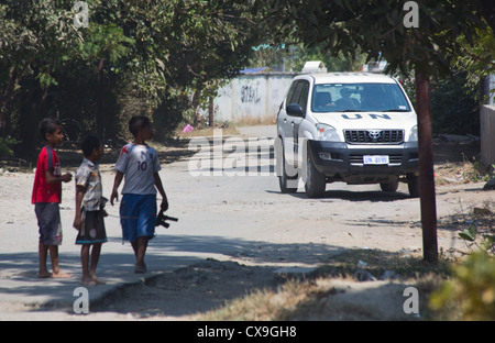 Niños mirando un vehículo de las Naciones Unidas, Dili, Timor Oriental Foto de stock