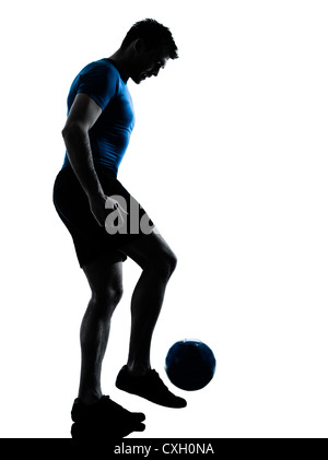 Un hombre caucásico jugando fútbol jugador de fútbol de malabarismo silueta en studio aislado sobre fondo blanco.