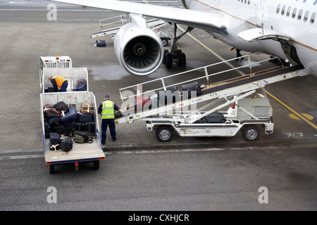 Los manipuladores de equipaje de carga Boeing 757 de United Airlines en el aeropuerto internacional de Belfast Foto de stock