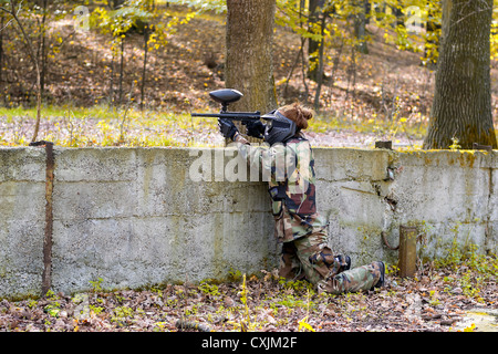 Jugador de Paintball con ropa de camuflaje shooting oponente de cubierta  durante un torneo de paintball Fotografía de stock - Alamy