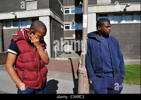 Dos jóvenes desempleados jóvenes Leeds UK, uno habla por teléfono.