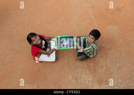 Poblado Indio, niña y niño con un mundo escrito en una pizarra en una aldea india. En Andhra Pradesh, India Foto de stock