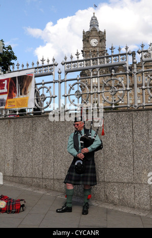 Cuando un piper juega en Waverly bridge en Edimburgo Foto de stock
